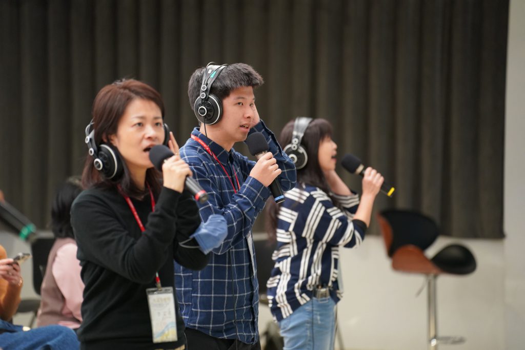 天韻音樂營敬拜者培訓的學員們體驗如何聽監聽喇叭或IEM（耳內監聽系統）。